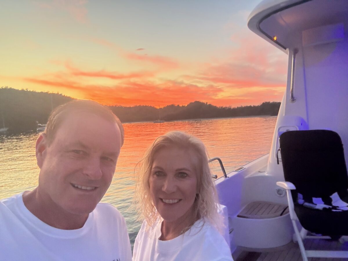 Devin Doyle and his wife enjoying a peaceful sunset together aboard a boat.
